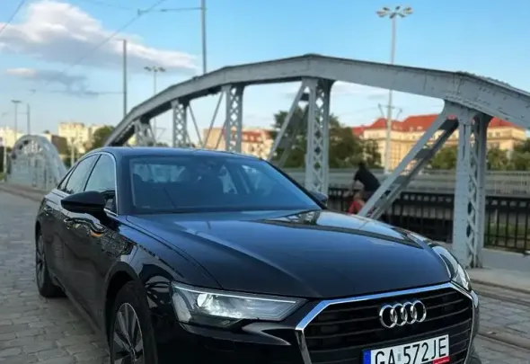 אאא Audi A6 שחורה חדשה, בצבע שחור, מהשכרת הרכב Kaizen Rent, עומדת על הגשר