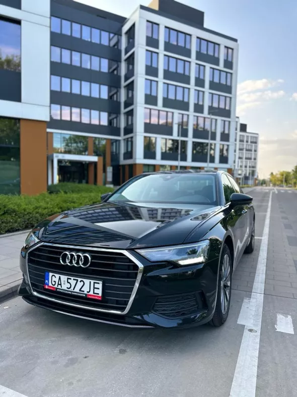 Audi A 6 z wypożyczalni Kaizen Rent zaparkowane na nowoczesnym osiedlu w mieście