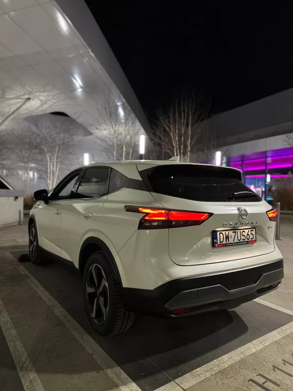 Biały Nissan Qashqai z floty Kaizen Rent zaparkowany na parkingu w centrum miasta