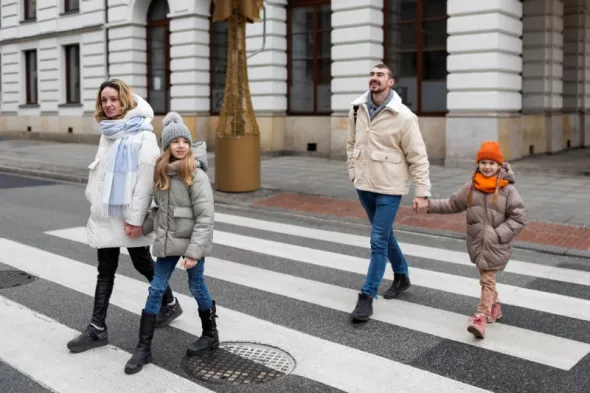 Pieszy na pasach -  rodzina przechodzi przez jezdnię w dozwolonym miejscu