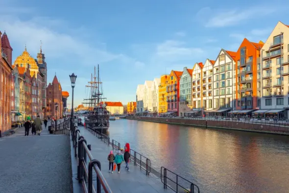 Gdańsk waterfront along the Motława River with historic buildings and riverside embankment in Poland