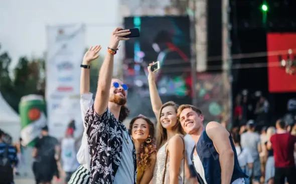 A group of young people are taking photos of themselves at a festival in Poland