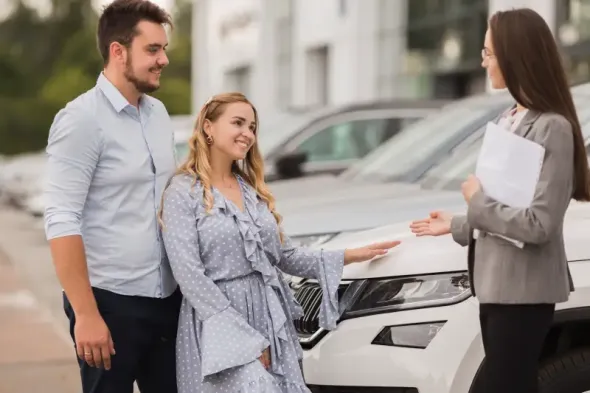 Couple speaking with car rental agent in office