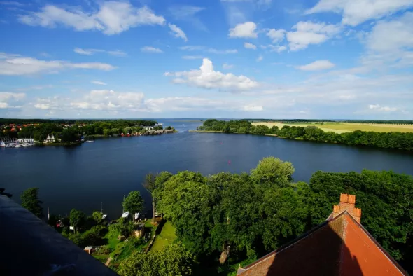 View of Lake Mazurskie surrounded by trees and fields