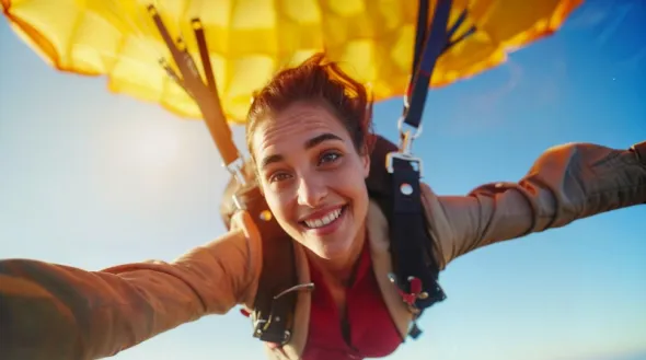 Młoda kobieta szybuje w przestworzach na paralotni