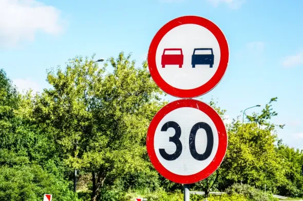 A road sign in Poland indicating a speed limit of 30 km/h and a ban on overtaking