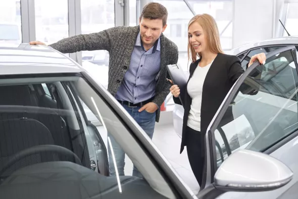 A Kaizen Rent customer looks over a car with a advisor