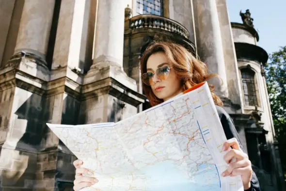 Woman holding a tourist map while exploring Warsaw, Poland
