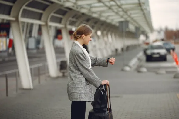 Woman with suitcase at the airport preparing for a flight from Warsaw to Krakow