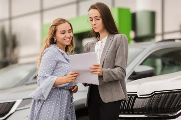 Woman reviewing paperwork at car rental office