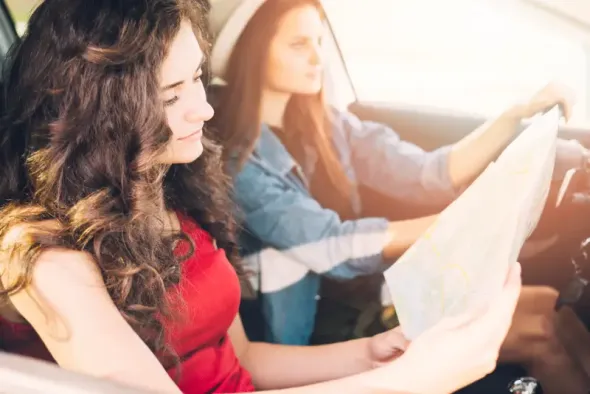 Young woman driving car in Poland while looking at map