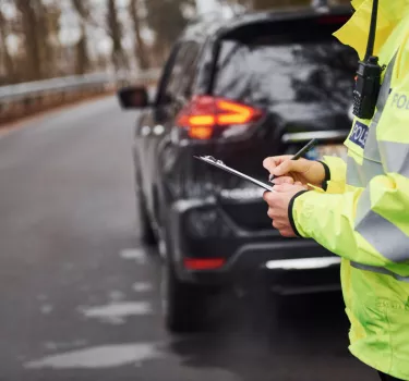 Policjant wystawia mandat. Jakie kary w 2025 roku. Aktualny taryfikator mandatów i punktów karnych