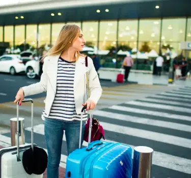 Traveller with suitcases outside the airport terminal