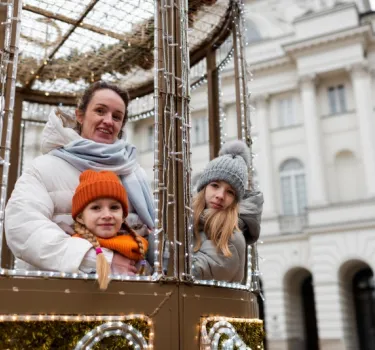 A mother and her children enjoy the festive atmosphere at the Christmas market in Gdańsk. 