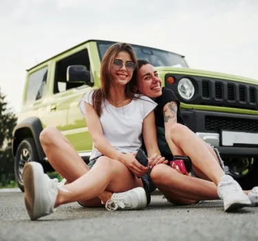 Dwie młode przyjaciółki dobrze bawią się podczas babskiego wypadu samochodem