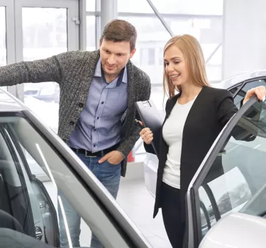 A customer and a Kaizen Rent advisor look over a car