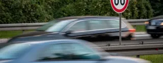 A speed limit sign indicating 80 km/h on a busy road in Poland, with many cars travelling along the motorway.