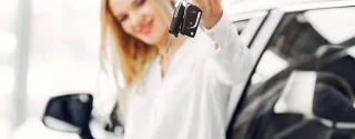 A beautiful blonde picks up the keys to her rental car.
