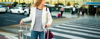 Traveller with suitcases outside the airport terminal