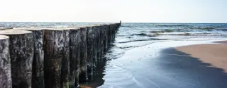 Wooden breakwaters on the sandy beach in Sianożęty on the Baltic coast