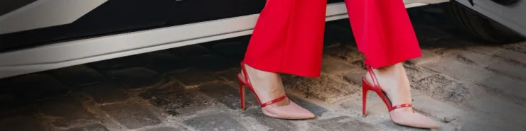 Zoom na czerwone szpilki kobiety siedzącej w samochodzie