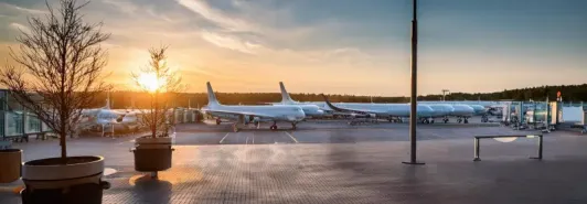 Airplanes at sunset on runway with orange sky