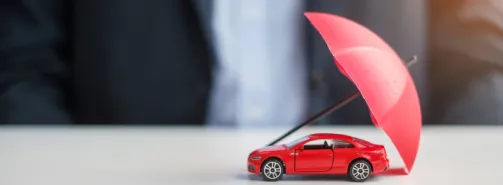 Rental car under an umbrella symbolizing car rental insurance protection in Poland.