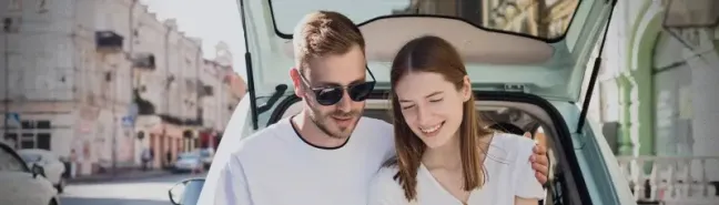 A couple looking at a city map while touring in a hire car