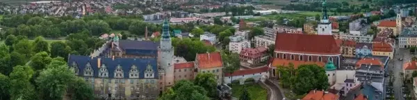 Zamek w Oleśnicy i panorama miasta o zachodzie słońca z lotu ptaka