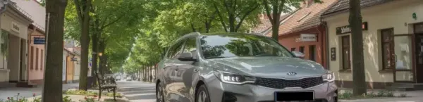 Zgierz-nowoczesny samochód osobowy stoi na tle zielonej alei w centrum małego polskiego miasta