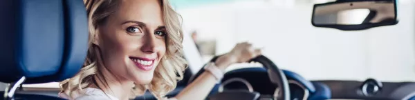 Uśmiechnięta dziewczyna w wynajętym samochodzie Kaizen Rent