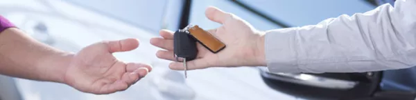 Przedstawiciel Kaizen Rent przekazuje kluczyki do wynajętego w wypożyczalni samochodu 